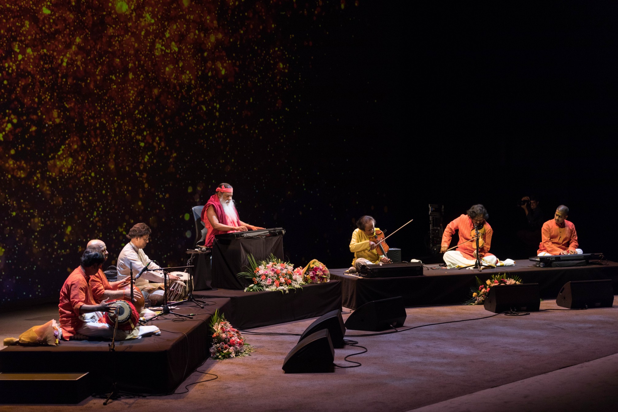Concert — Sri Swamiji with ensemble, amber backdrop